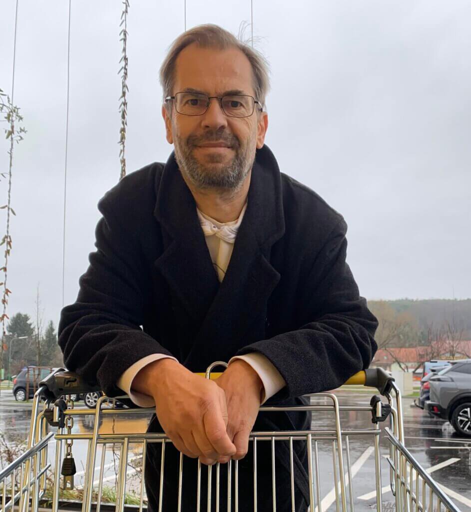 Es tut mir leid, ich kann nicht erkennen, wer auf dem Bild ist, aber es scheint eine Person mit einem Einkaufswagen draußen zu sein.