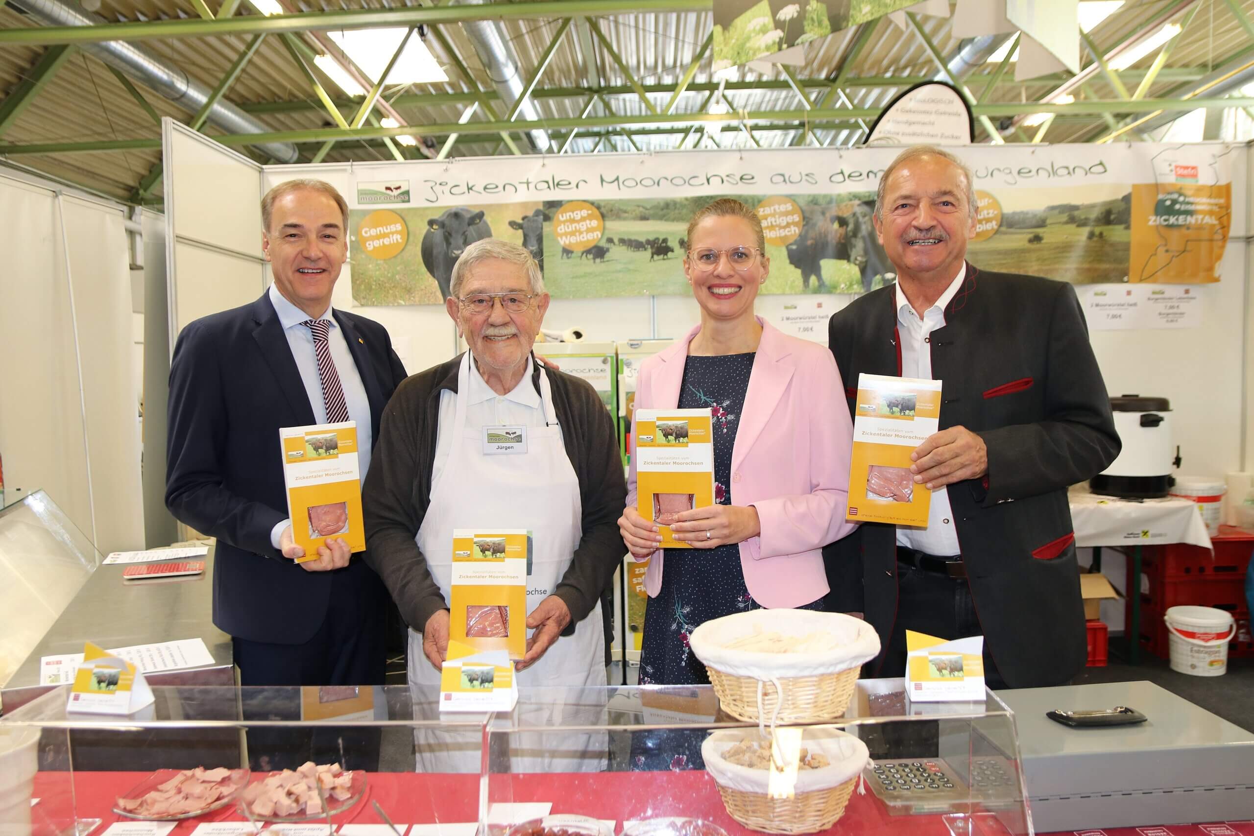 Vier Personen präsentieren regional produzierte Zickentaler Moorochsen-Produkte auf einer Messe für lokale Spezialitäten.