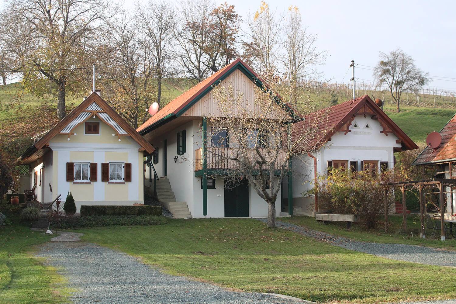 Drei malerische Landhäuser in herbstlicher Landschaft; Symbol für regionalen Charme und Wohnen im Grünen, Prima Magazin.
