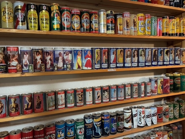 Regale voller bunter Sammler-Bierdosen in vielfältigen Designs, die verschiedene Marken und nostalgische Motive zeigen.