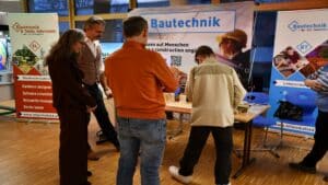 Besucher informieren sich bei einem Stand über Elektronik und Bautechnik auf einer Messe, präsentiert von HTL Pinkafeld.