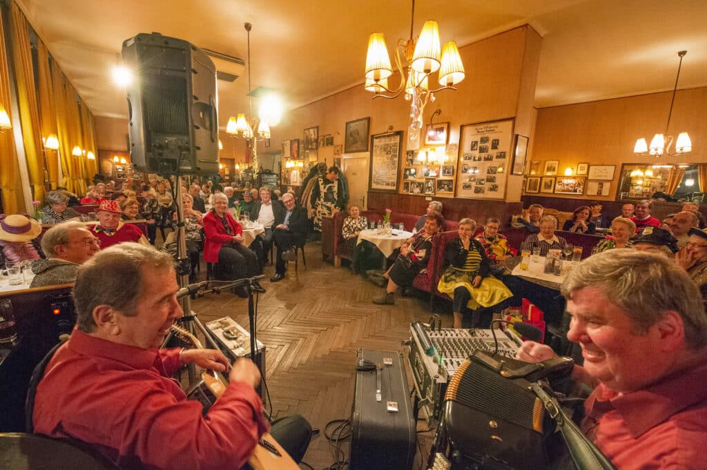 Geselliges Beisammensein in einem gemütlichen Café mit Livemusik und gut gelaunten Gästen, geeignet für Prima Magazin.