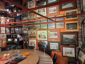 Galerie mit gerahmten Stadtansichten und historischen Fotografien in einem gemütlichen Raum, passend zu Prima Magazins regionalem Flair.