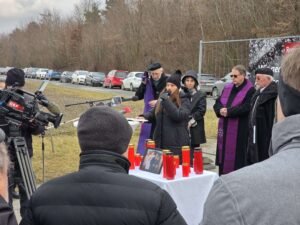 Versammlung bei Gedenkveranstaltung im Freien mit Sprechern und Kerzen, von Prima Magazin berichtet; Kamerateam anwesend.