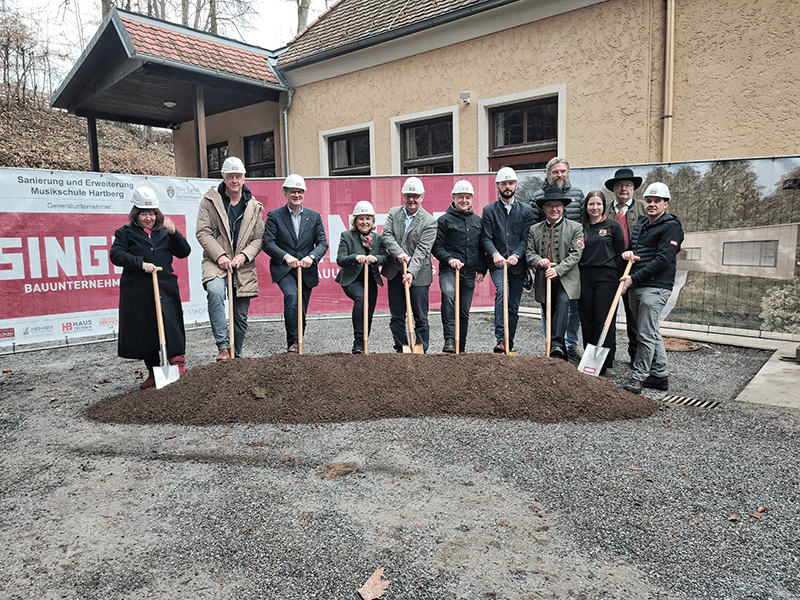 Personen feiern den Spatenstich für die Erweiterung der Musikschule Hartberg. Ein Moment des regionalen Engagements.